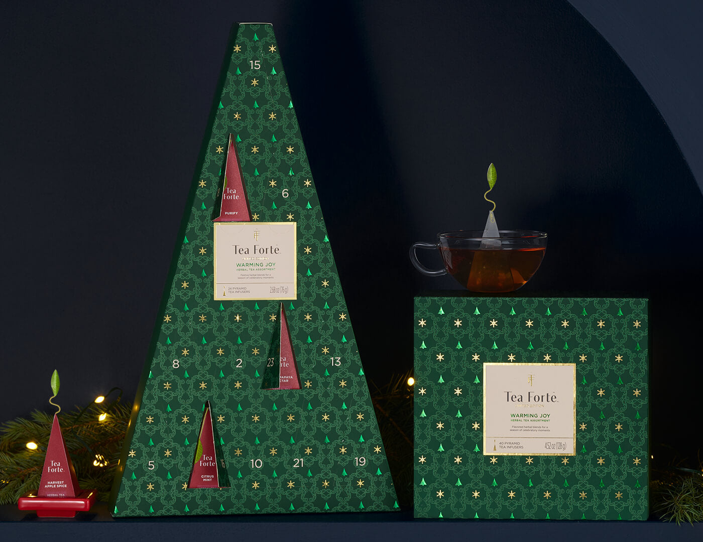 Warming Joy Herbal Advent Calendar with doors open, plus an Herbal Tea Chest and cup of tea on a shelf